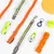 Accessoires pour chien : laisses, colliers, jouet orange, balle jaune Nomad Tales, frisbee jaune, lampes LED, mousqueton et accessoires réfléchissants visibles sur fond blanc.