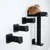 Set tiragraffi da parete con tre gradini e una superficie per sdraiarsi, design nero. Gatto seduto sulla superficie imbottita.