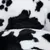 Close-up of black and white patterned plush material, possibly for pet products such as beds or blankets.