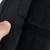 Nahaufnahme eines schwarzen Klettverschlusses an einem Produkt, der von einer Hand geöffnet wird.