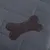 Detailaufnahme einer dunkelgrauen, gesteppten Oberfläche mit einem aufgenähten braunen Lederknochen.