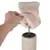 Assembling a scratching post element: hand pulls beige plush cover over metal rod and sisal column.