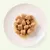 Cibo umido per animali in bocconcini servito su un piatto bianco, con salsa visibile.