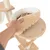 Hand showing removable, padded cushion on a cat tree platform. Beige fabric with visible white inner padding.