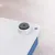 Gros plan sur un coin d’un objet en plastique blanc avec patin antidérapant rond noir et trou visible dans l’angle.