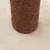Detail van een krabpaal met bruin sisaltouw omwikkeld, staand op een beige pluche ondergrond. Materiaal: sisal en pluche zichtbaar.