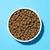 Bowl filled with dry brown kibble pieces, shown from above to display the size and shape of the food.