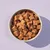 Bowl filled with small, brown, cube-shaped pet food pieces.