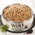 Wet food in a stainless steel bowl with Wolf of Wilderness logo, decorated with thyme, blackberries and red berries.