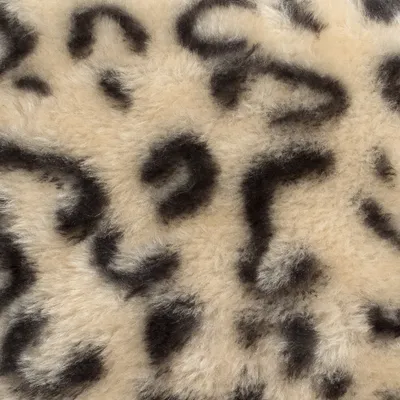 Close-up van een beige-zwart luipaardpatroon op zacht bontmateriaal.