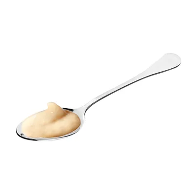 Silver spoon with creamy, beige paste. Shows the product's consistency.