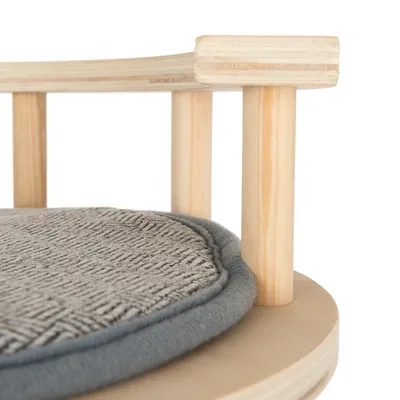 Detailansicht eines runden Holzgestells mit grauem, gepolstertem Kissen. Material: helles Holz und weicher Stoff.