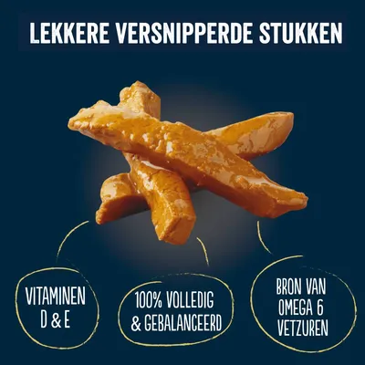 Tekst: Lekkere versnipperde stukken. Vitaminen D & E, 100% volledig & gebalanceerd, bron van omega 6 vetzuren. Afbeelding van bruine stukjes voer.