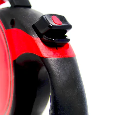 Primo piano di un manico nero e rosso con interruttore scorrevole, probabilmente parte di un guinzaglio per cani o accessorio simile.