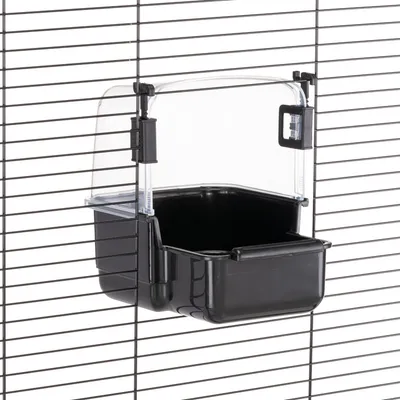 Zwarte voerbak met transparant deksel, bevestigd aan tralies. Geschikt voor kooien met verticale spijlen.