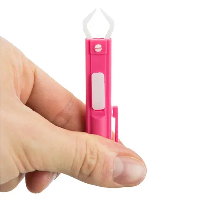 Pensetă pentru căpușe din plastic roz cu vârf de prindere alb, ținută în mână. Potrivită pentru îndepărtarea căpușelor.