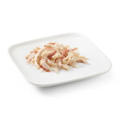 Close-up of tender white and red chicken meat strips on a white plate, shown as product image.