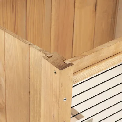 Vista dettagliata di un recinto in legno con pareti a griglia metallica e giunzioni a vite.