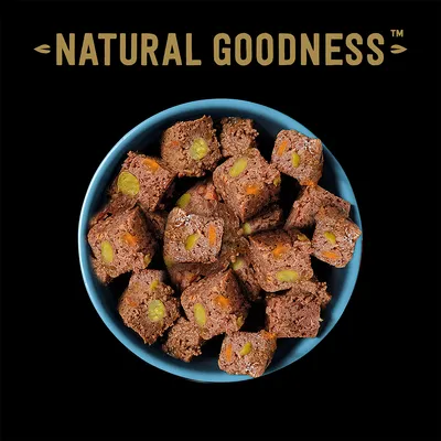 Natural Goodness. мясные кубики с видимыми кусочками овощей в синей миске.