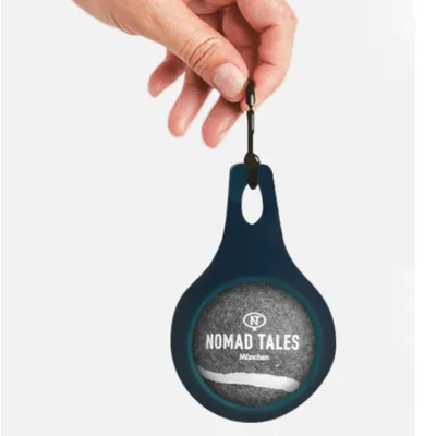 Nomad Tales München Anhänger mit schwarzem Karabiner, gehalten von einer Hand.