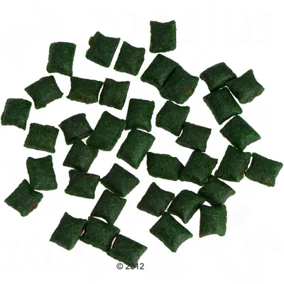 Zielone, poduszkowate kawałki karmy lub przysmaków dla zwierząt, widoczne w dużej ilości na białym tle. Materiał: sucha karma.
