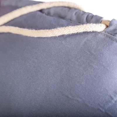 Close-up van donkerblauwe stof met beige touw, mogelijk onderdeel van een product of accessoire.