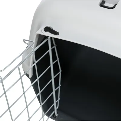 Transportbox met witte kunststof behuizing, zwarte binnenkant en metalen traliedeur. Detailweergave van de deurbevestiging.