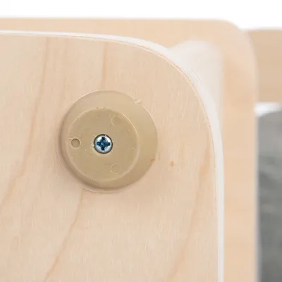 Nahaufnahme einer Holzverbindung mit beige Kunststoffabdeckung und Schraube. Zeigt Detail der Konstruktion.