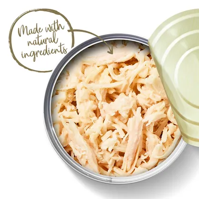 Avoin säilyketölkki, jossa vaaleaa revittyä lihaa. Kuvassa englanninkielinen teksti: Made with natural ingredients.