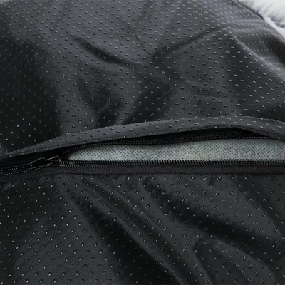 Nahaufnahme eines schwarzen, gepunkteten Stoffes mit Reissverschluss. Sichtbar ist die innere Schicht des Materials.