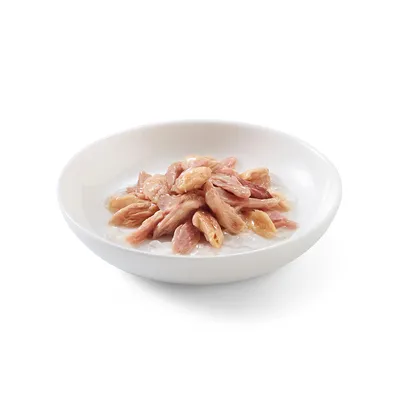Morceaux de viande rose dans une sauce blanche, présentés dans une assiette blanche. Aucun emballage ni marque visible.