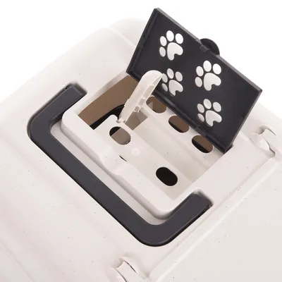 Detailansicht einer Transportbox mit geöffnetem Lüftungsschlitz und schwarzem Deckel mit Pfotenmuster.