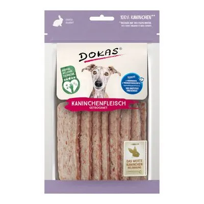 DOKAS Kaninchenfleisch gedroogd, verpakking met zichtbare staven. Tekst: 100% Kaninchen, Animal Welfare Star, Das Werte Kaninchen Belohnung. Hond afgebeeld op de voorkant.