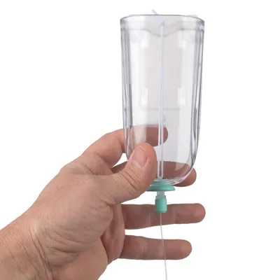 Mano tiene contenitore trasparente con valvola verde e tubo, adatto per razioni consigliate di liquidi o abbeveratoio per animali.