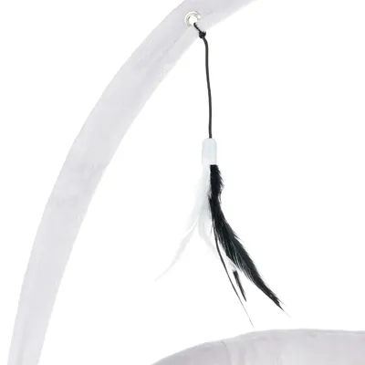 Jouet suspendu avec plumes noires et blanches attaché à une structure en tissu gris clair, visible sur l'image.