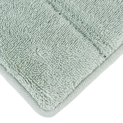 Primer plano de una superficie textil suave de color verde claro con microfibra estructurada.