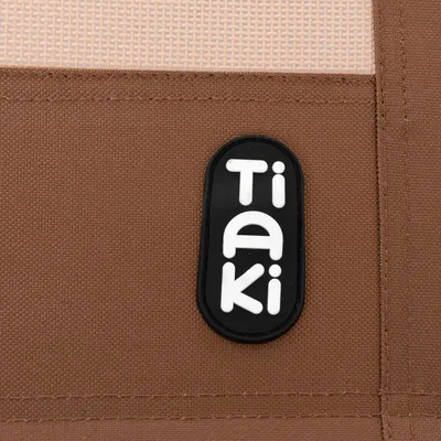 Tiaki-logo op bruine stoffen achtergrond.