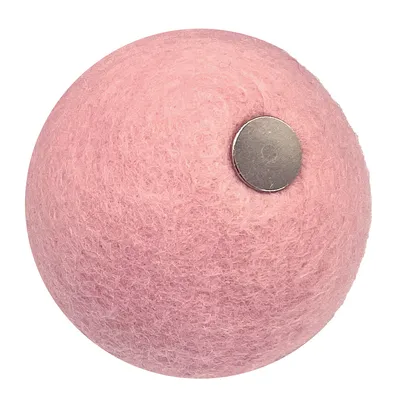Balle rose en feutre avec un disque métallique visible sur le côté, aucun texte ou marque apparente.