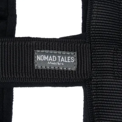 Nomad Tales München. Black textile collar with visible brand label.
