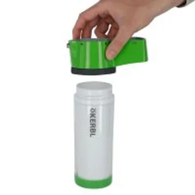 Biała butelka z napisem ÖKERBL i zielona nakrętka trzymana przez dłoń, widoczne dwa elementy produktu.