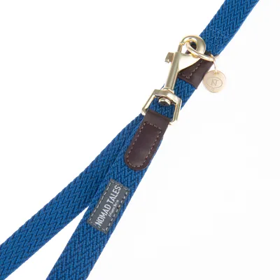 Nomad Tales Hundeleine aus blauem Stoff mit braunen Lederdetails und goldfarbenem Metallverschluss.