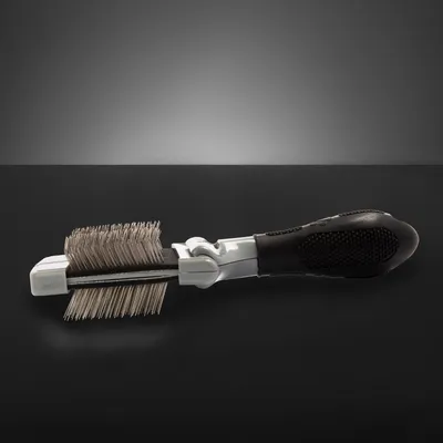 Metal brush with black ergonomic handle and double rows of bristles for coat care.
