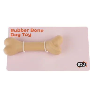 Гумена играчка за кучета Rubber Bone, бежов гумен кокал върху розова карта с ADE-лого.