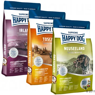 Tre poser Happy Dog Supreme Sensible Nutrition hundefoder: Irland (adult laks & kanin), Toscana (adult lam & laks), Neuseeland (adult lam & ris). Synlig tekst på tysk og engelsk.