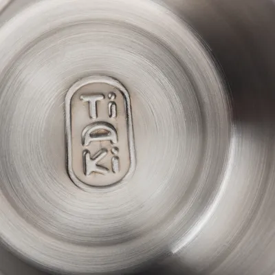 Gros plan sur le fond en acier inoxydable avec logo gravé 'Tiaki'.