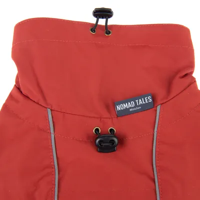Rode stof met trekkoord en reflecterende strepen, label 'Nomad Tales München' zichtbaar.