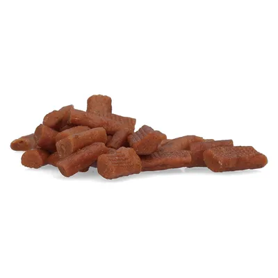 Bruine, cilindervormige hondensnacks of -trainingshapjes zonder zichtbare verpakking of merknaam, gestapeld op een witte achtergrond.