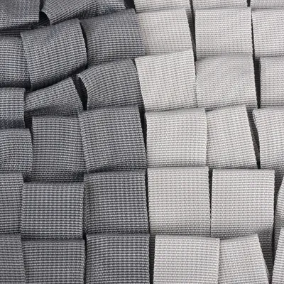 Nærbillede af et vævet stofmønster i grå og hvide nuancer, viser materialets tekstur og design.