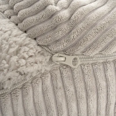 Close-up van een ritssluiting op een zachte, geribbelde stof met een pluche binnenvoering.