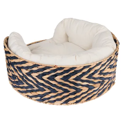 Rundes Haustierbett mit geflochtenem Korbdesign in Blau und Naturfarben, gepolstertem weissen Kissen für Komfort.
